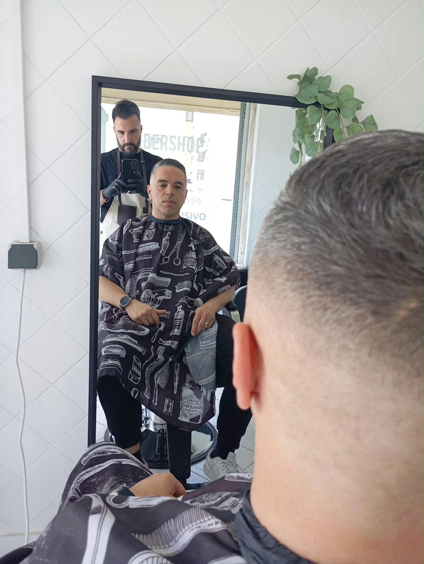 Cliente a ser atendido na ARJ Barbearia, vista do espelho